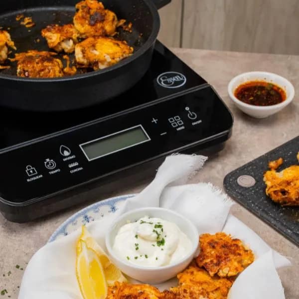 Anafe a inducción Essen acompañado de cacerolas Essen compatibles con tecnología de inducción